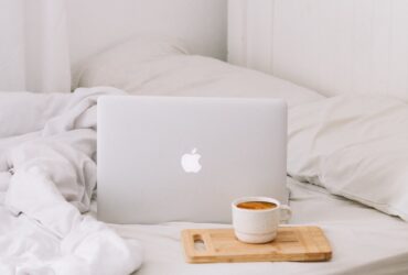 MacBook beside teacup with latte