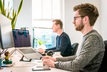 5 Best Microsoft Office 365 Alternatives 129 man sitting on chair wearing gray crew-neck long-sleeved shirt using Apple Magic Keyboard