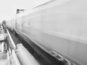 a black and white photo of a train passing by