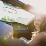 smiling woman sitting inside the vehicle at daytime